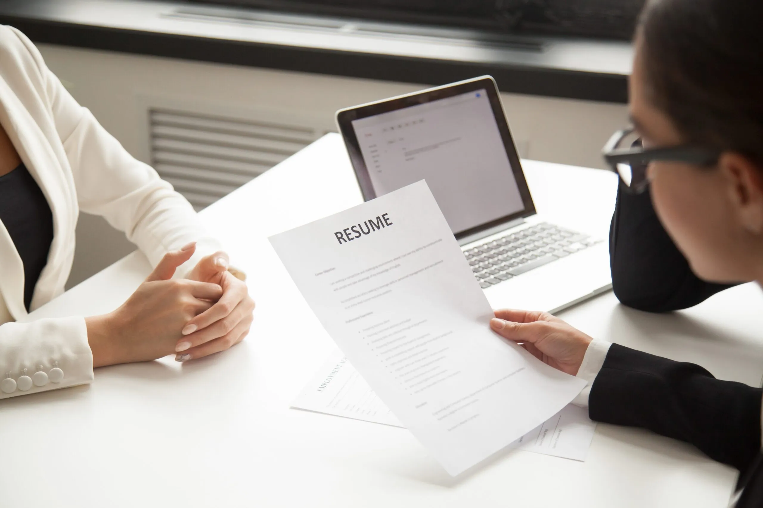 Rekruter analizujący CV kandydata podczas rozmowy kwalifikacyjnej